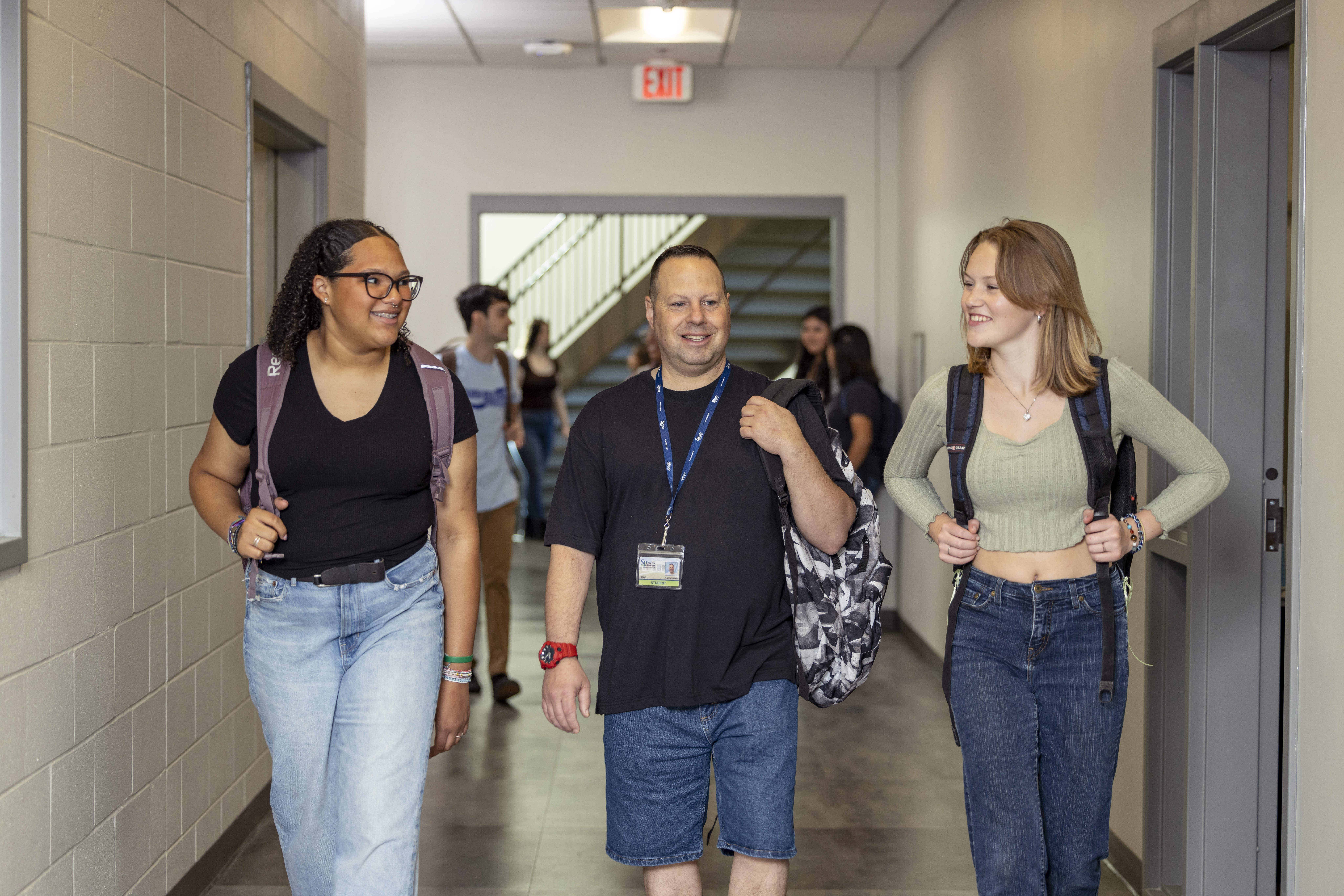 South Piedmont students walking down the hallway, having a conversation and smiling at one another.