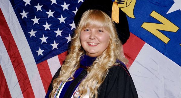 Photo of Diana Xavier, a South Piedmont graduate, in front of an American flag.