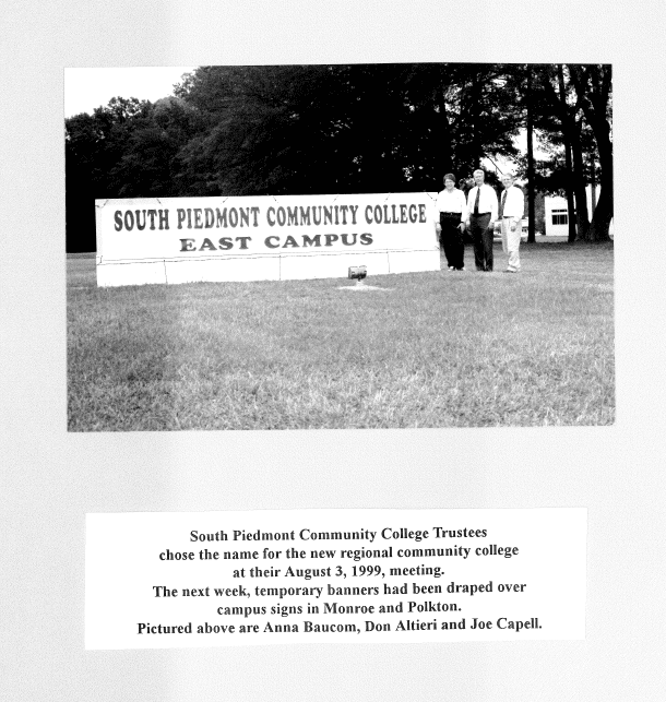South Piedmont Community College Board of Trustees standing beside the newly unveiled college banner.