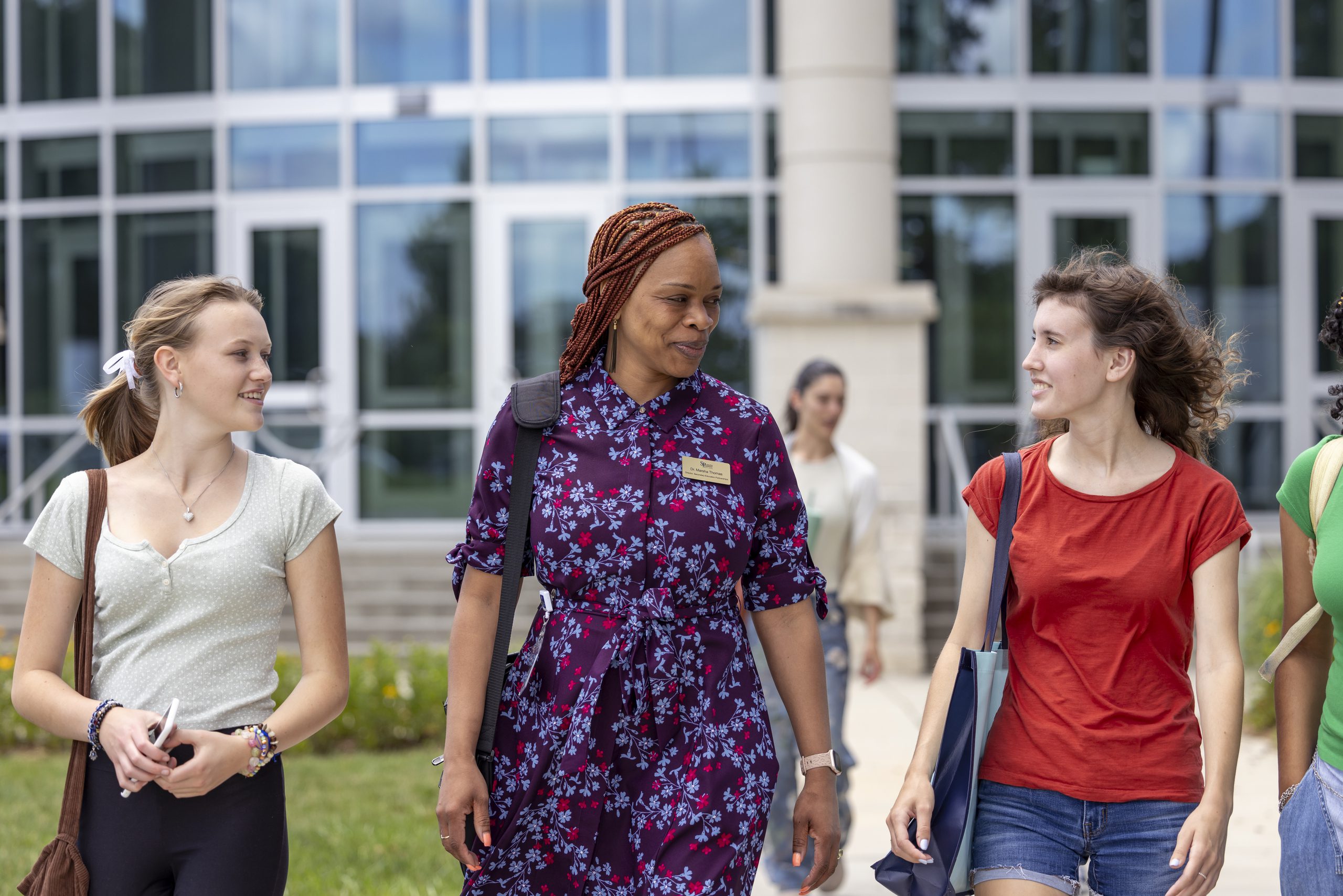 Marsha Thomas, Director of Learning Support, walking outside the OCH Main building alongside two students