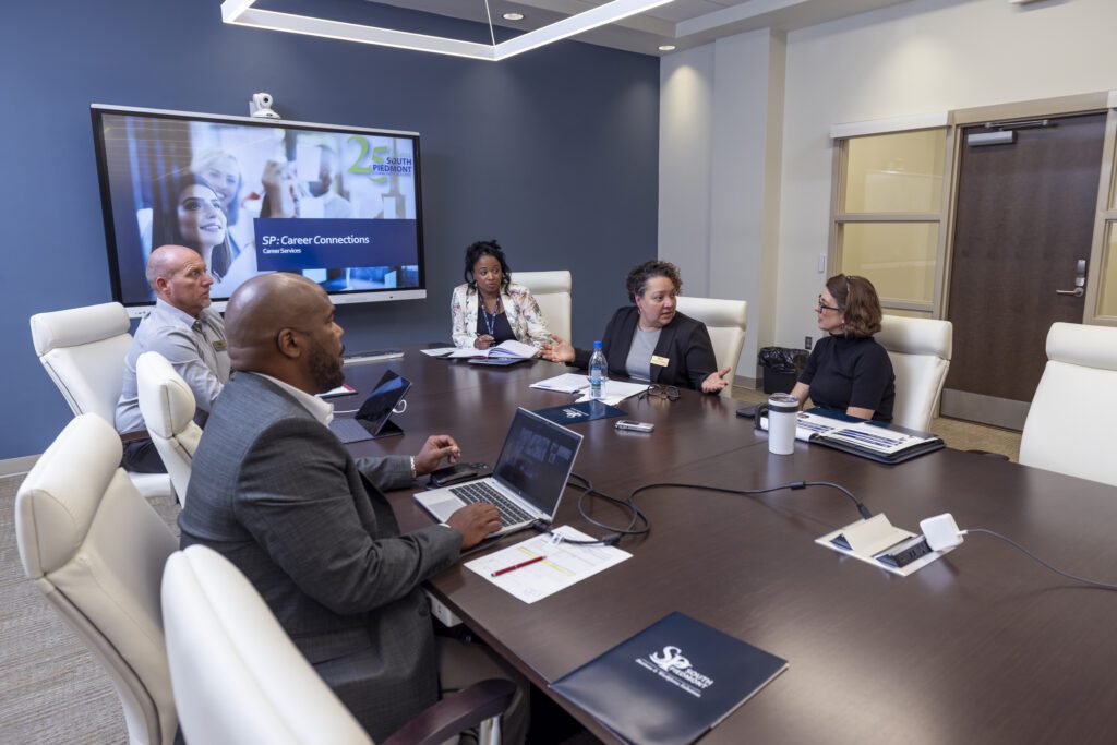 Business & Workforce Solutions members having their meeting.