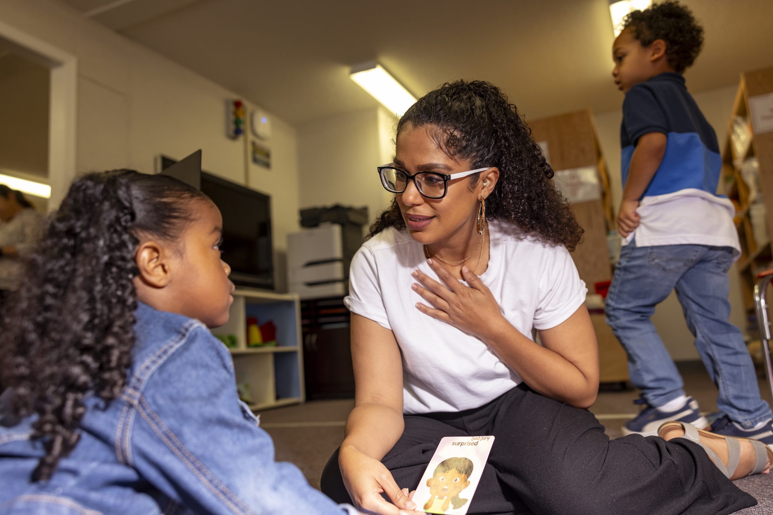 Teacher with a toddler in play room.