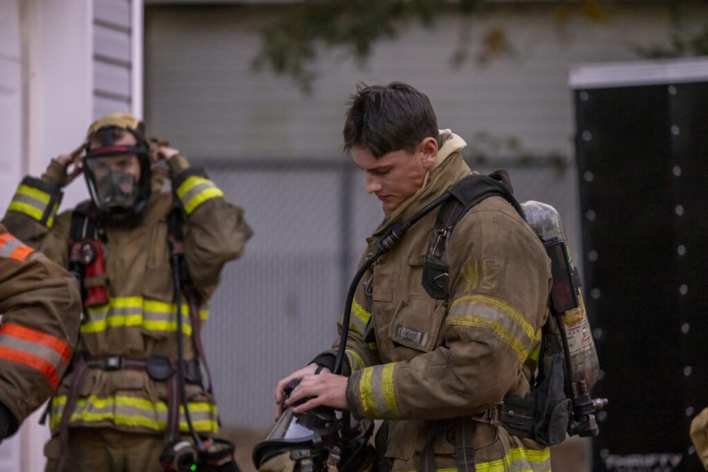South Piedmont firefighting student holding his helmet.