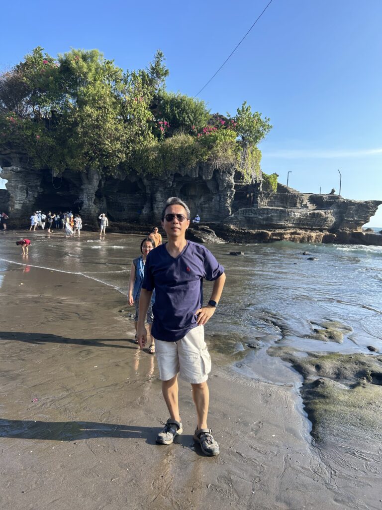 Photo of a man in a blue shirt standing in a stream.