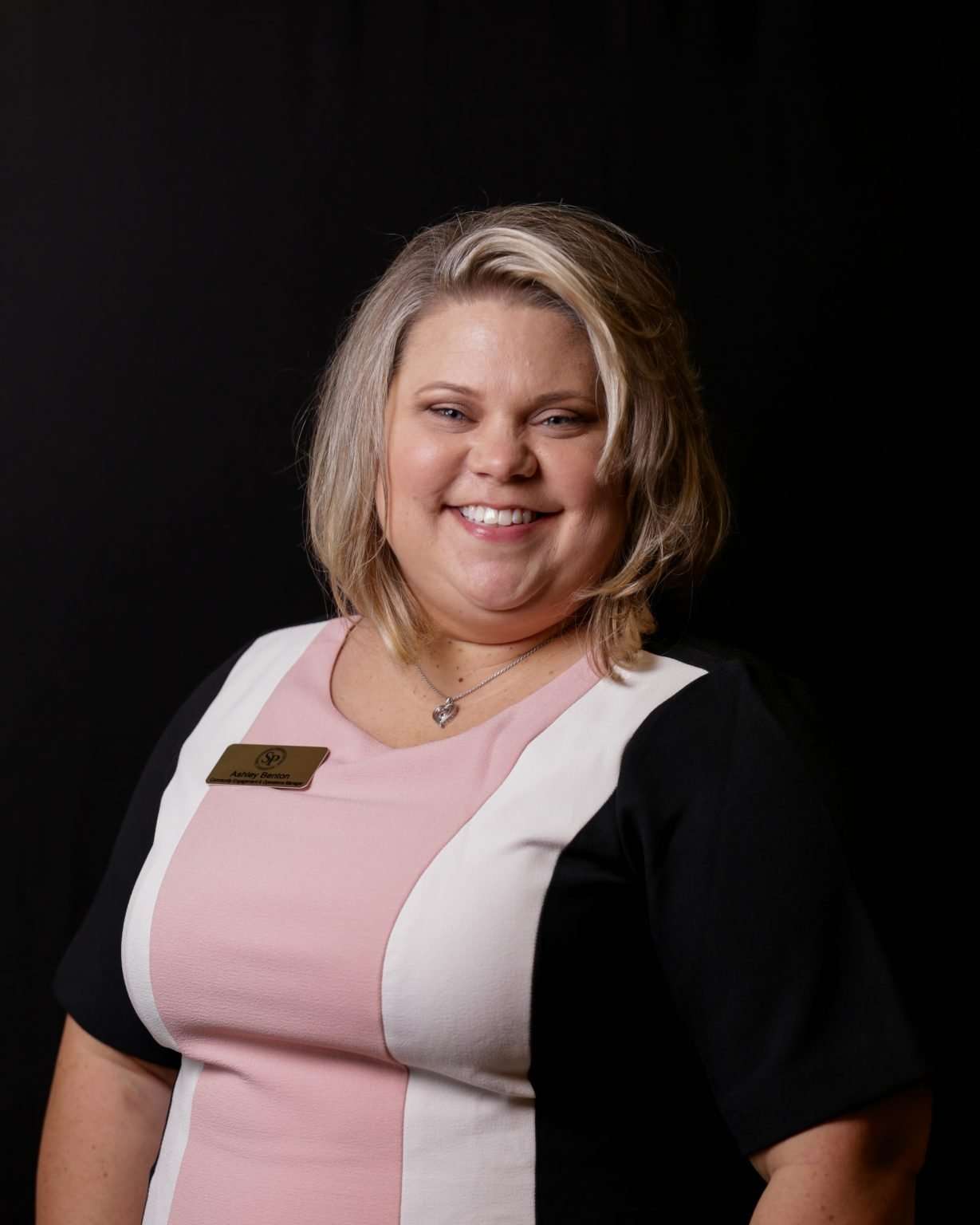 Photo of a woman in a pink, white and black dress.