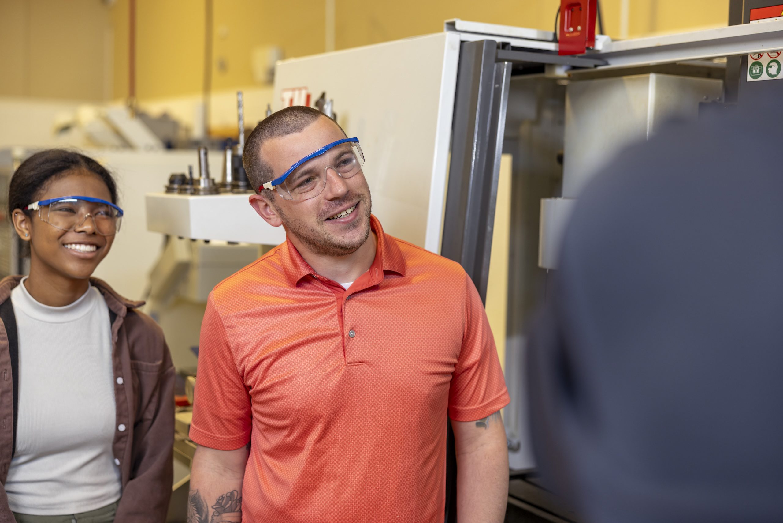 Two students inside of a classroom South Piedmont's Tyson Family Center for Technology, looking at teacher's demonstration of equipment