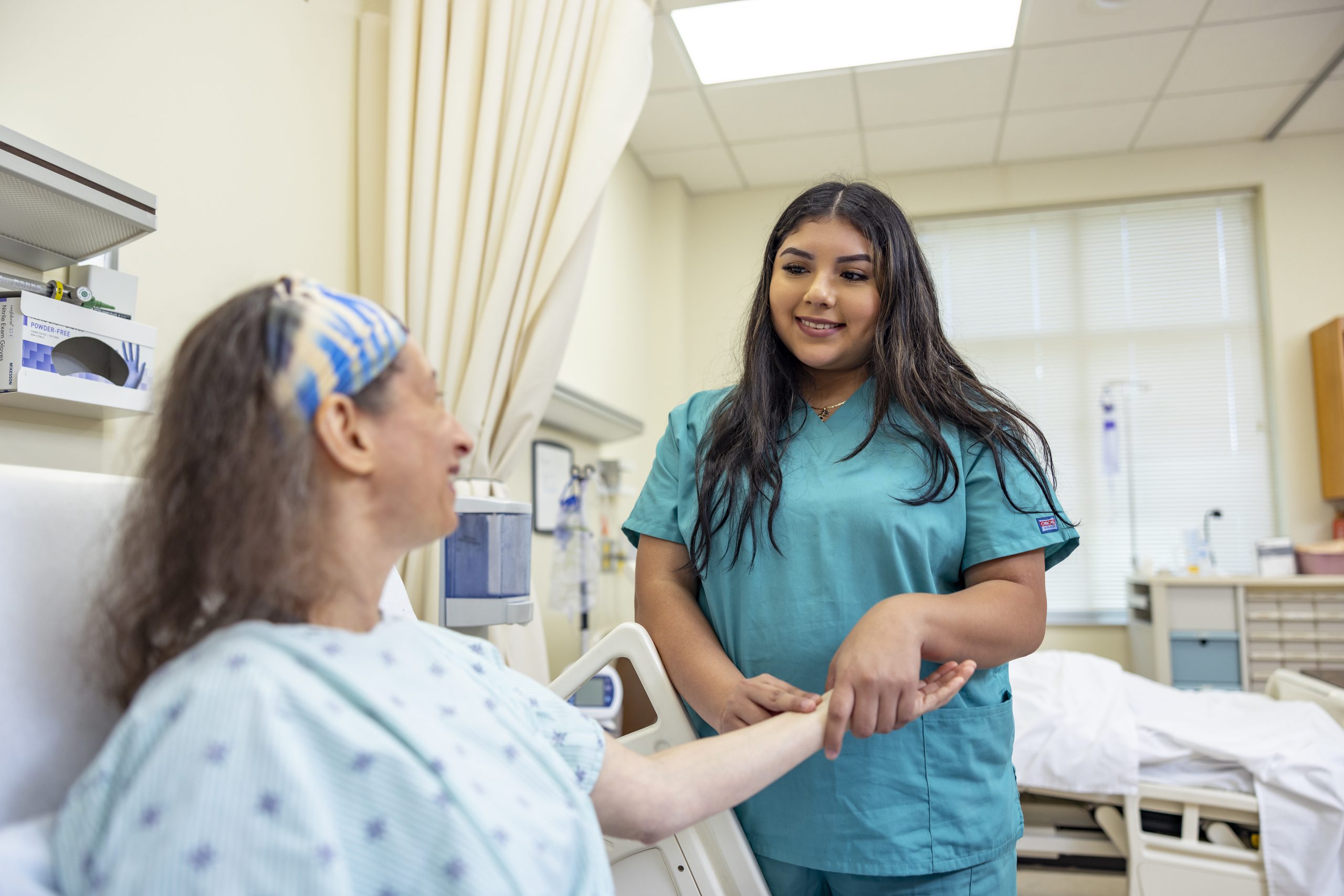 Female Medical Assisting student checking pulse of a patient.