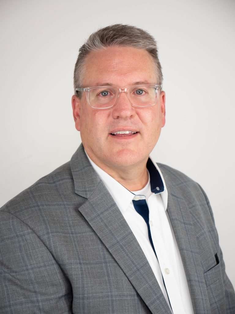 Photo of a man in a grey jacket.