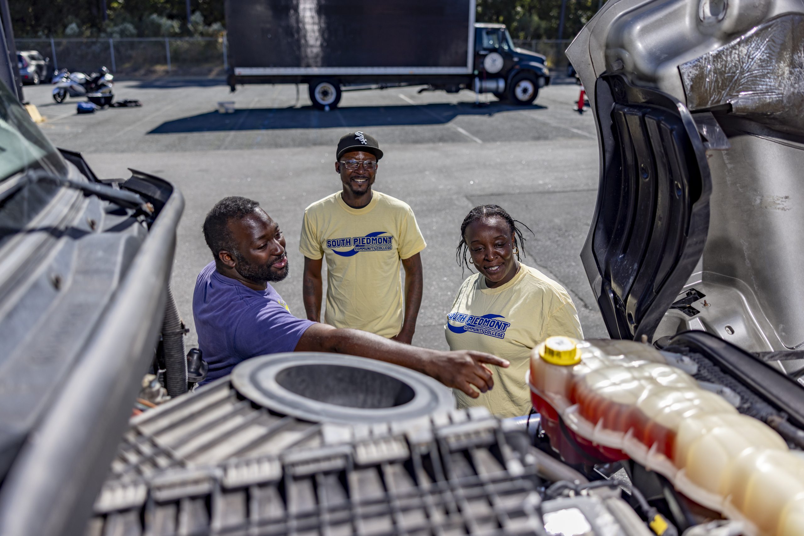 Students and an instructor inspecting the truck engine.