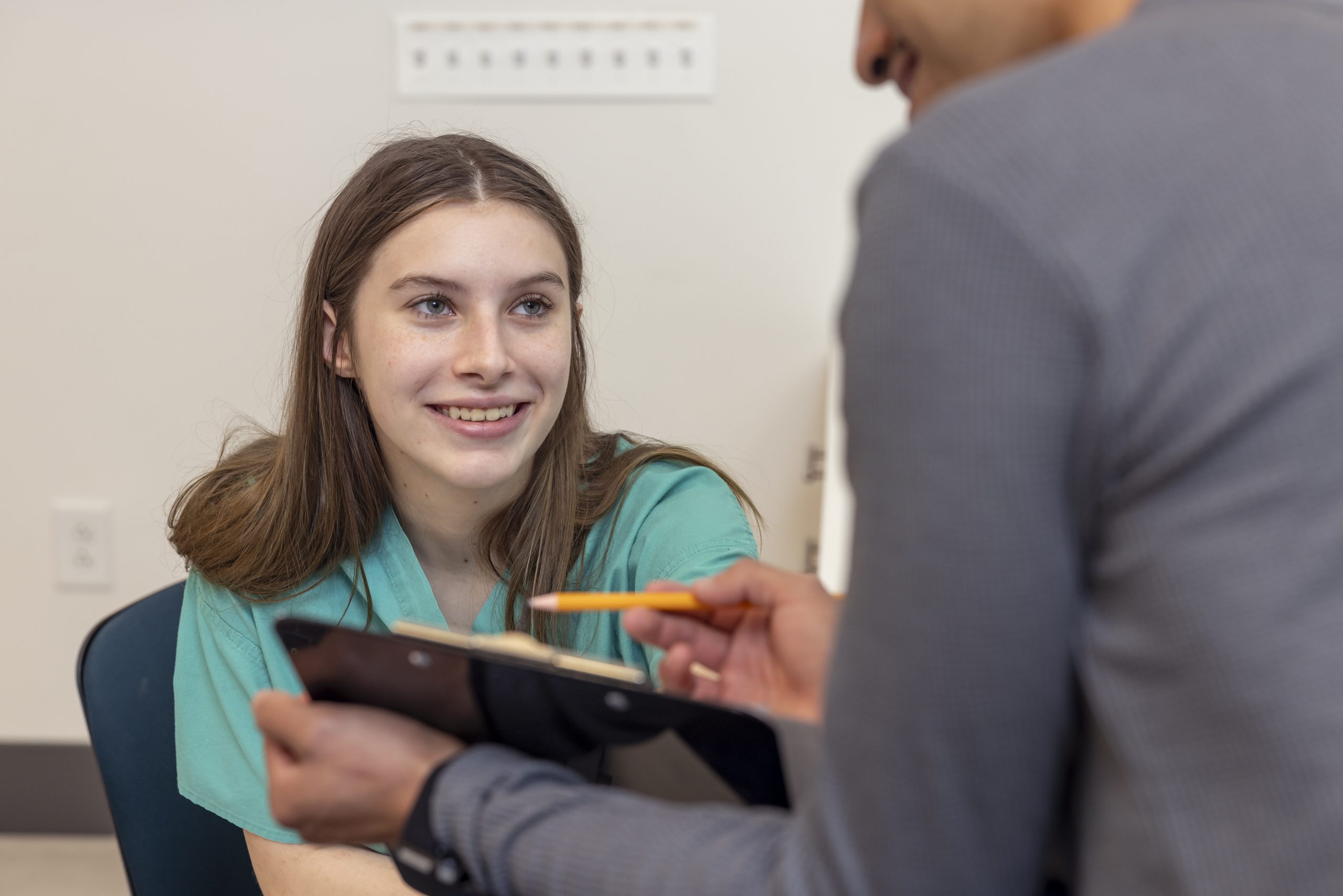 Female student smiling at another student.