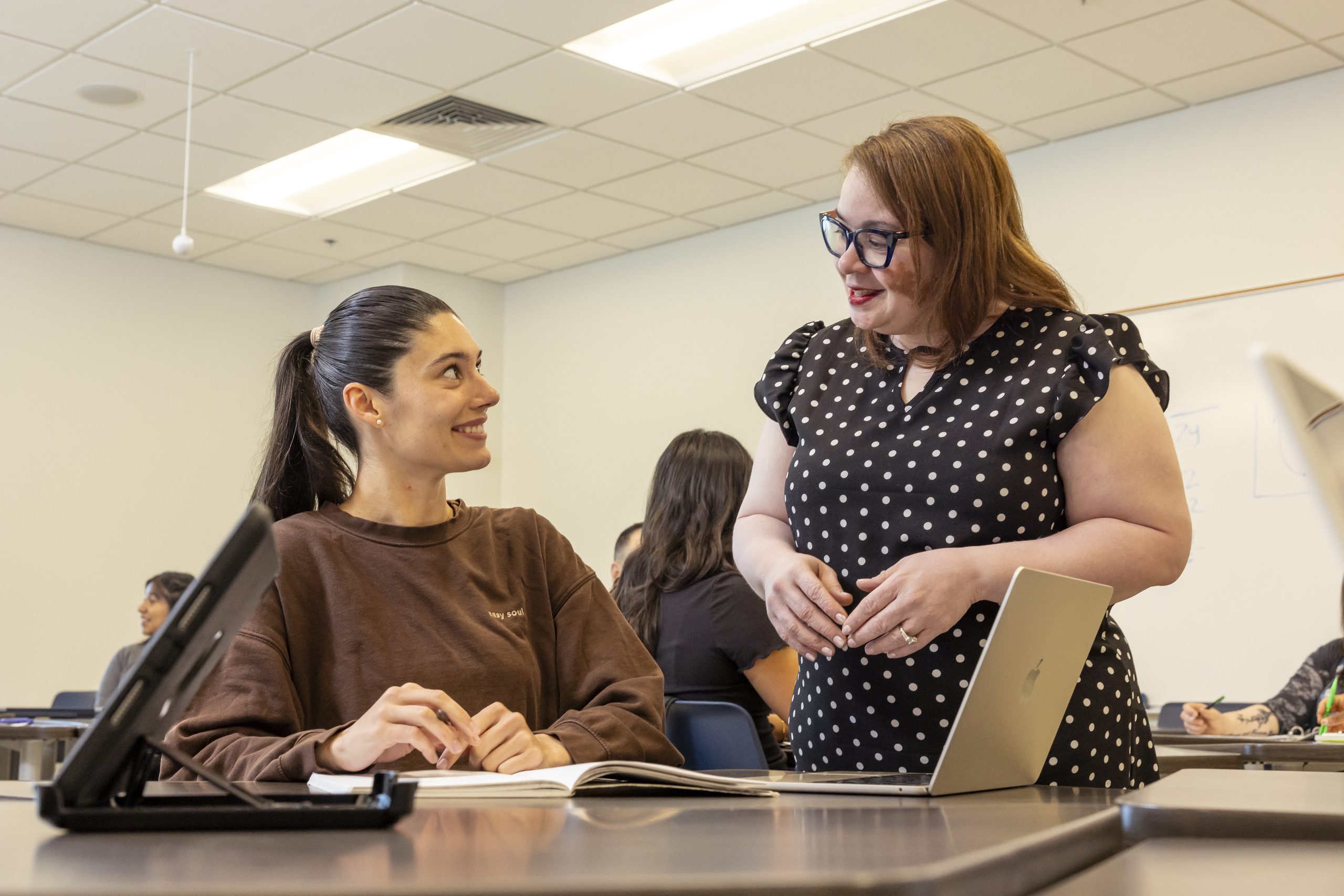 Teacher and student in a classroom setting.