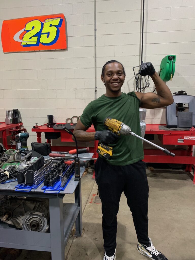 Amir, a student in South Piedmont's automotive program, holding tools he uses in the program.