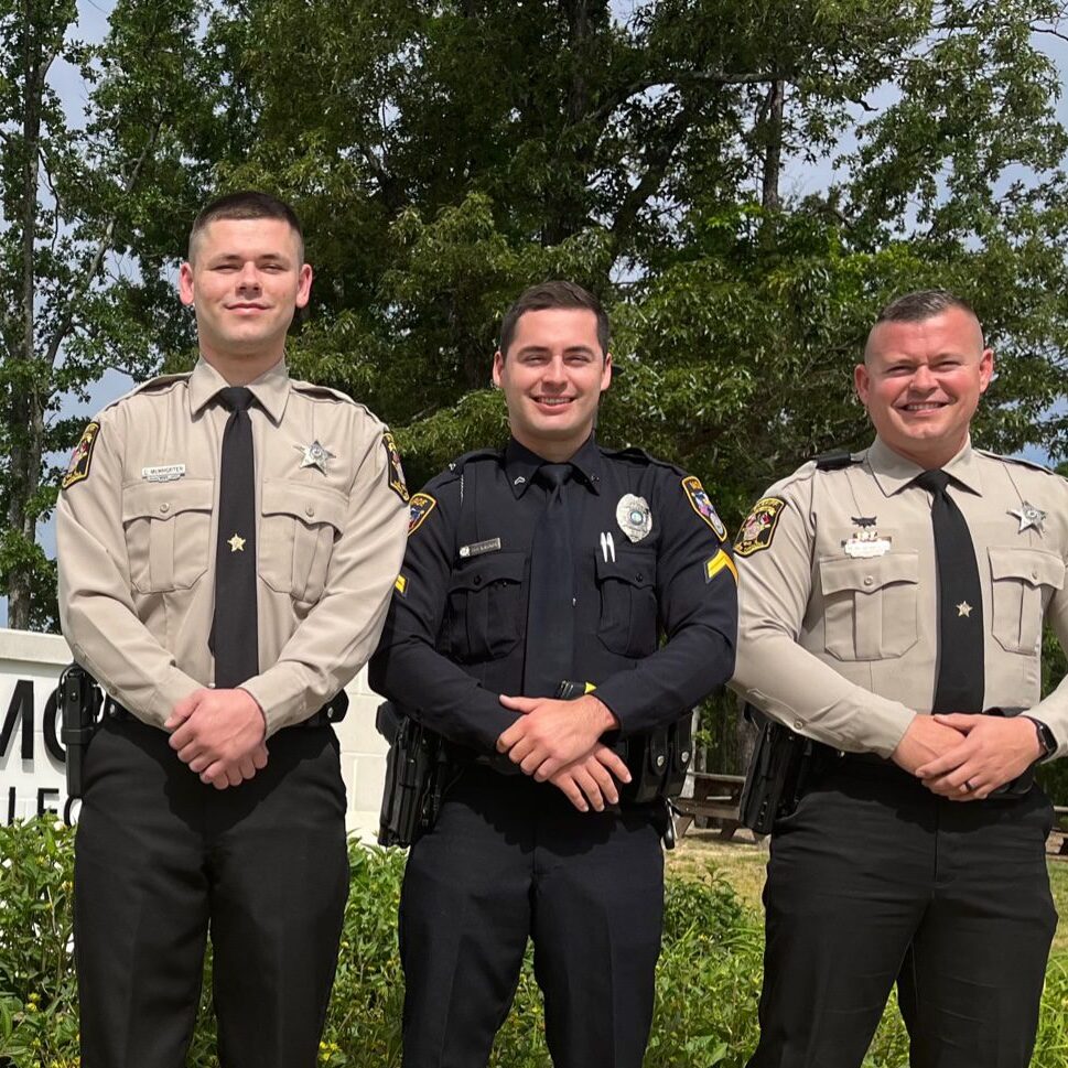 Three South Piedmont law enforcement students standing in uniform in front of the South Piedmont Main Building.