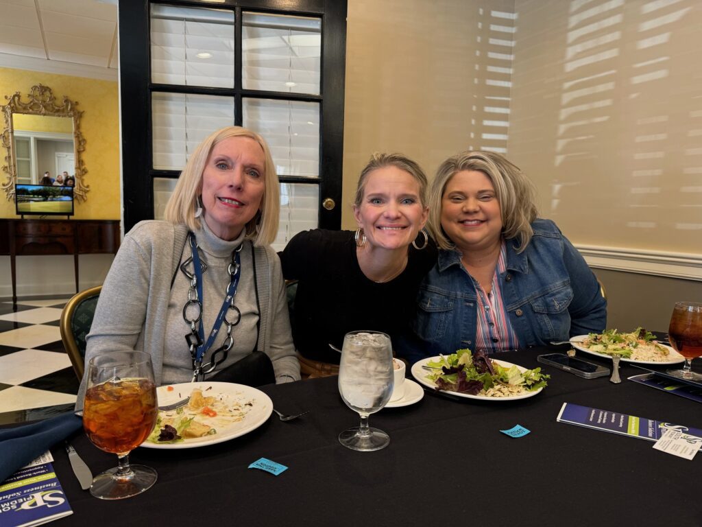 Three women who work at the South Piedmont Foundation sitting at a table after having lunch.