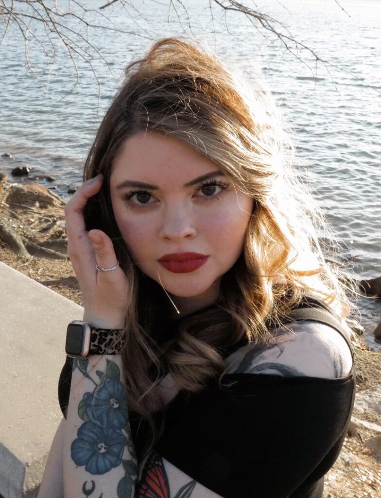 Madi, a South Piedmont alumna, sitting next to a river.