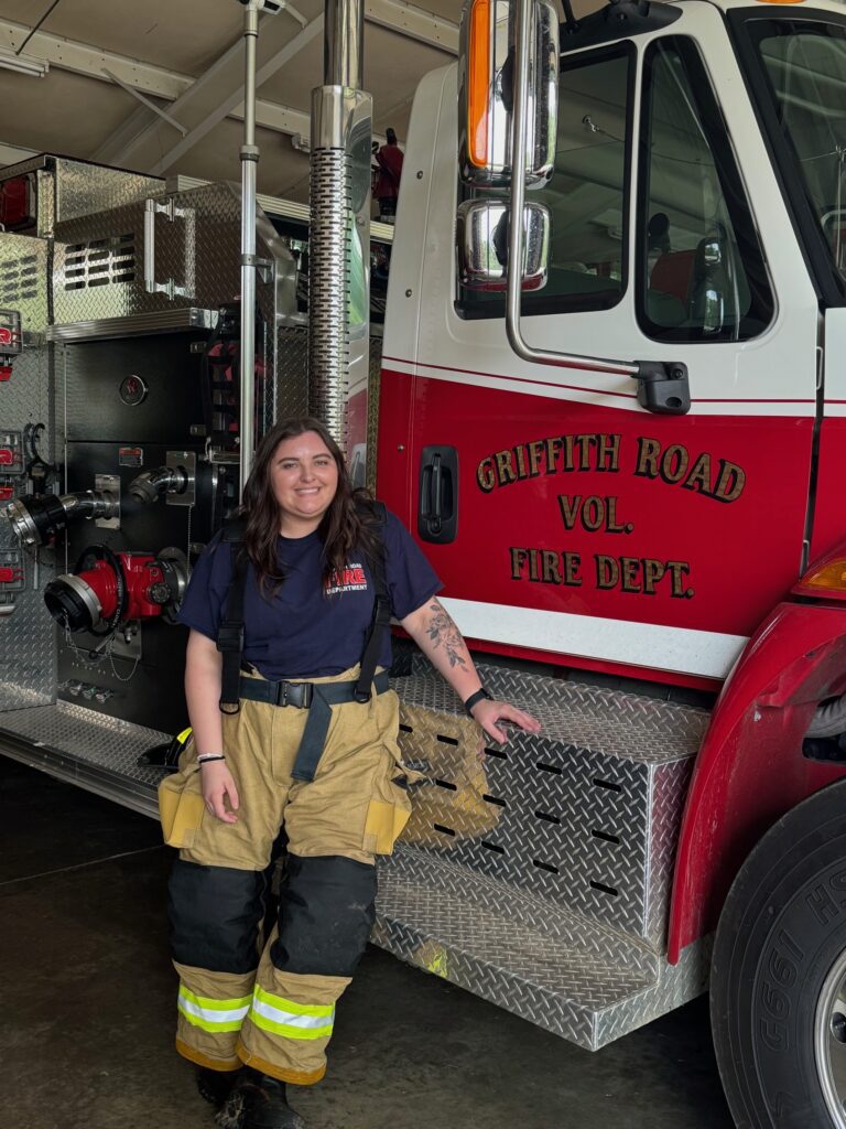 Olivia Geese in front of a fire truck.