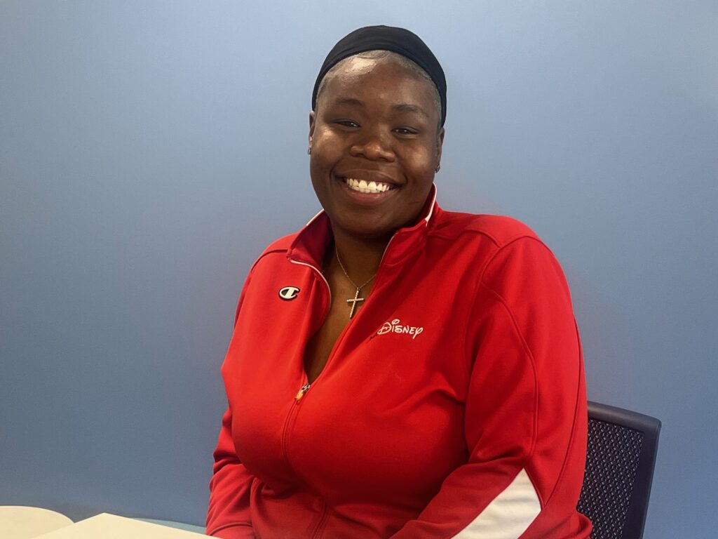 Photo of Yasmine Townsend in a red shirt smiling at the camera.