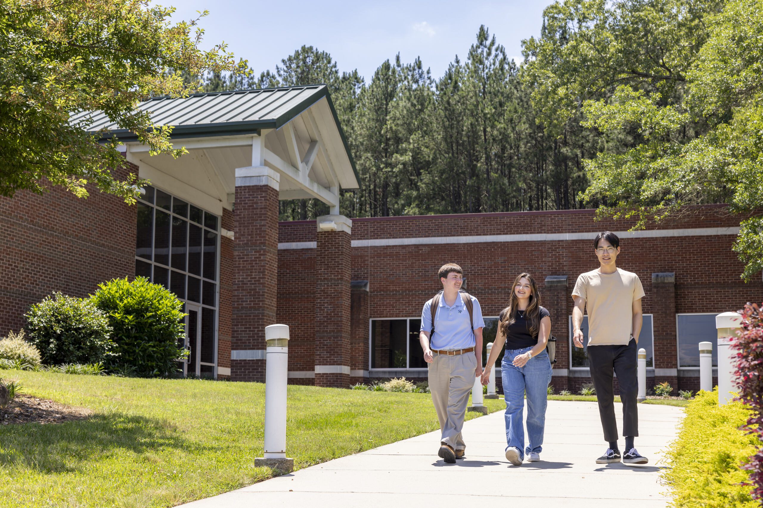 Three students walking outside of the Polkton campus building.