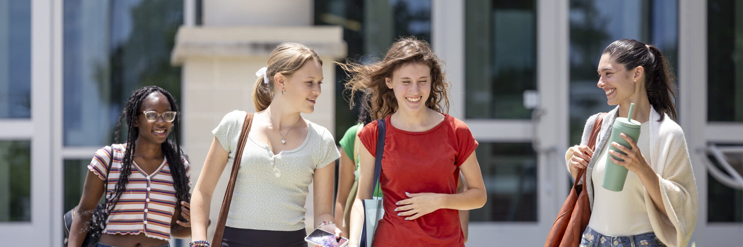 Students walking outside of the Main Building entrance.