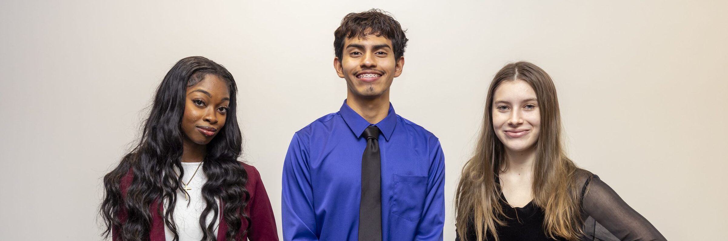 Three students in business casual clothing.