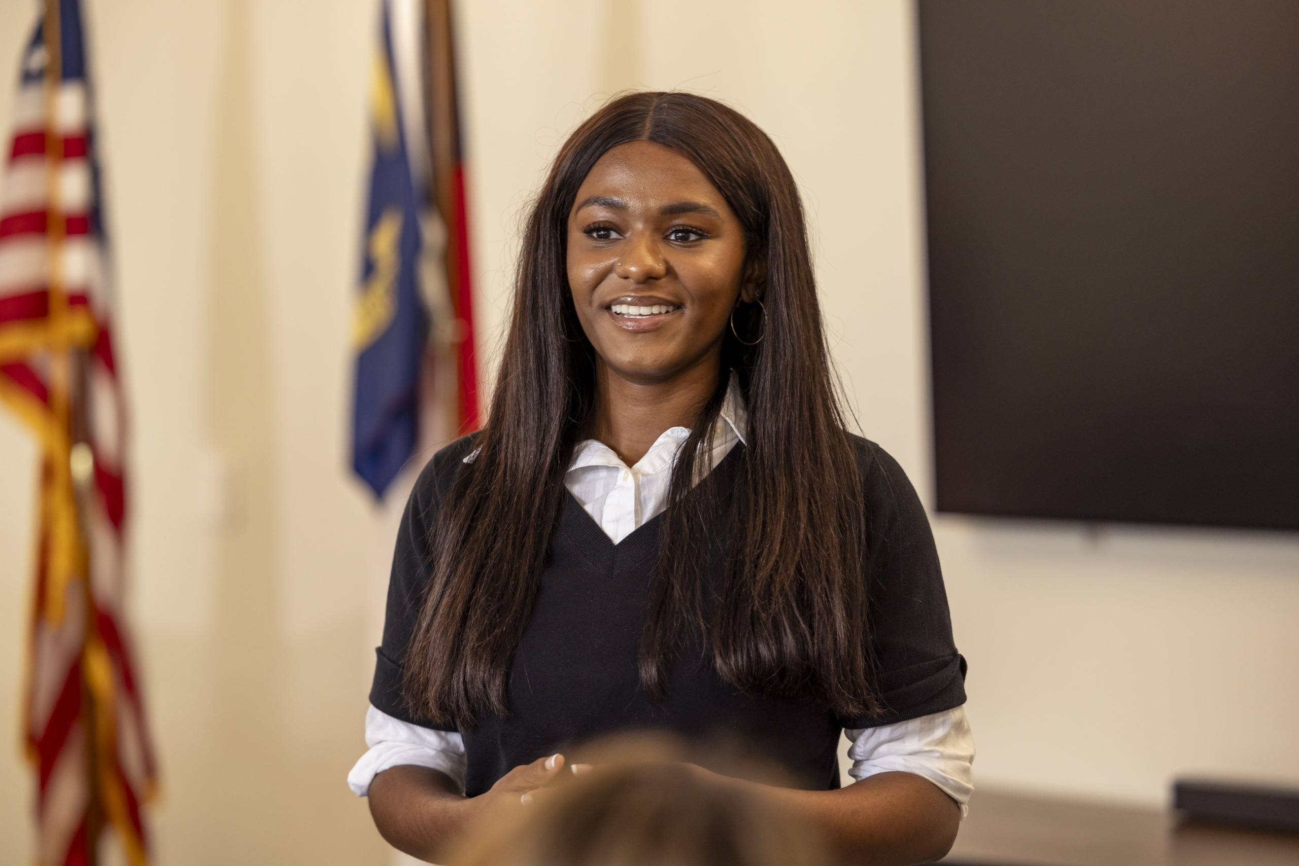 A South Piedmont student in a business casual outfit giving a presentation to her peers in a classroom setting.
