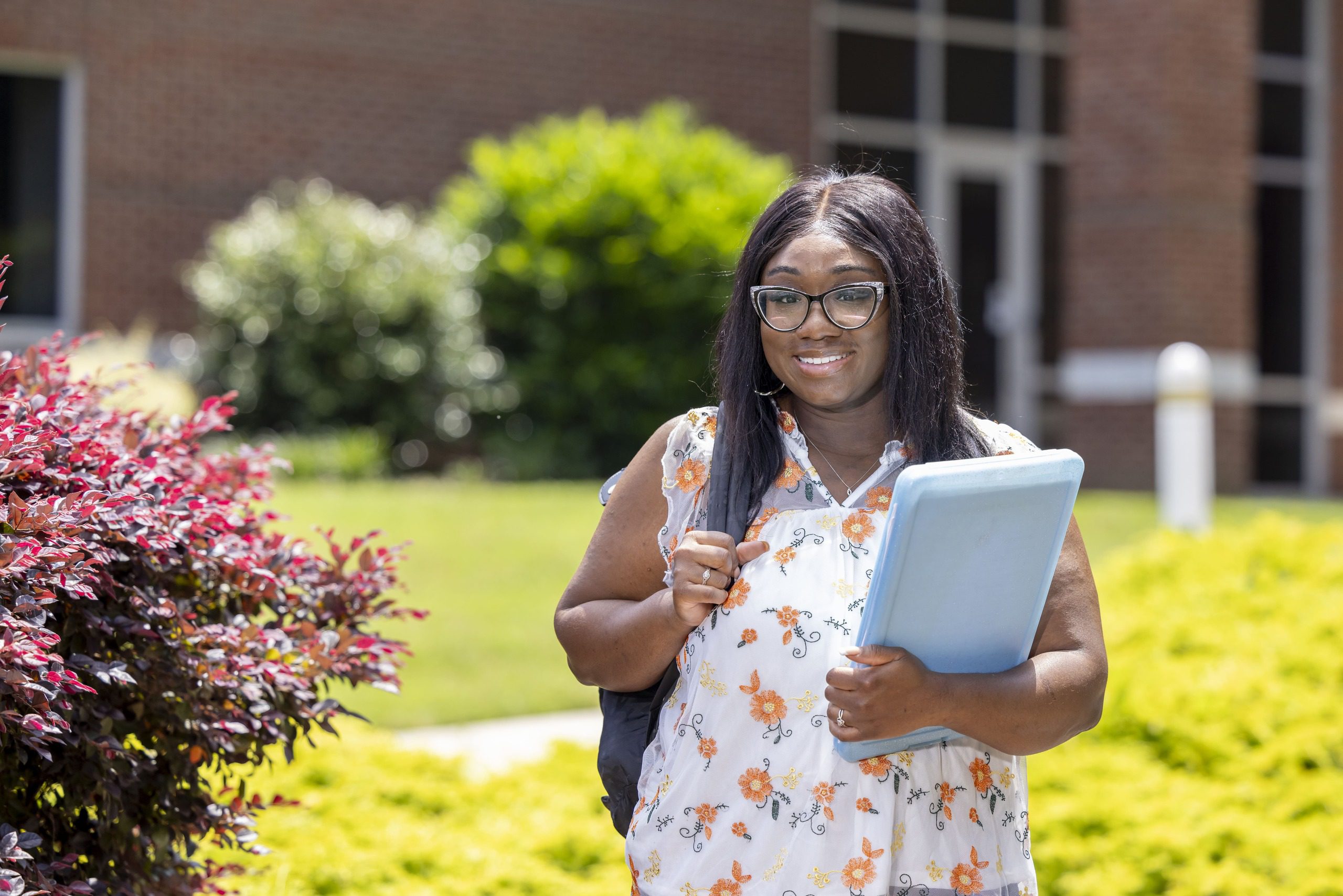 Female student with a laptop and a backpack.