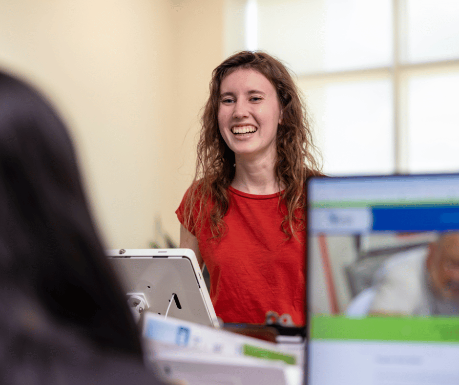 Photo of a girl smiling at a counter at the front lobby of South Piedmont's Main Building.