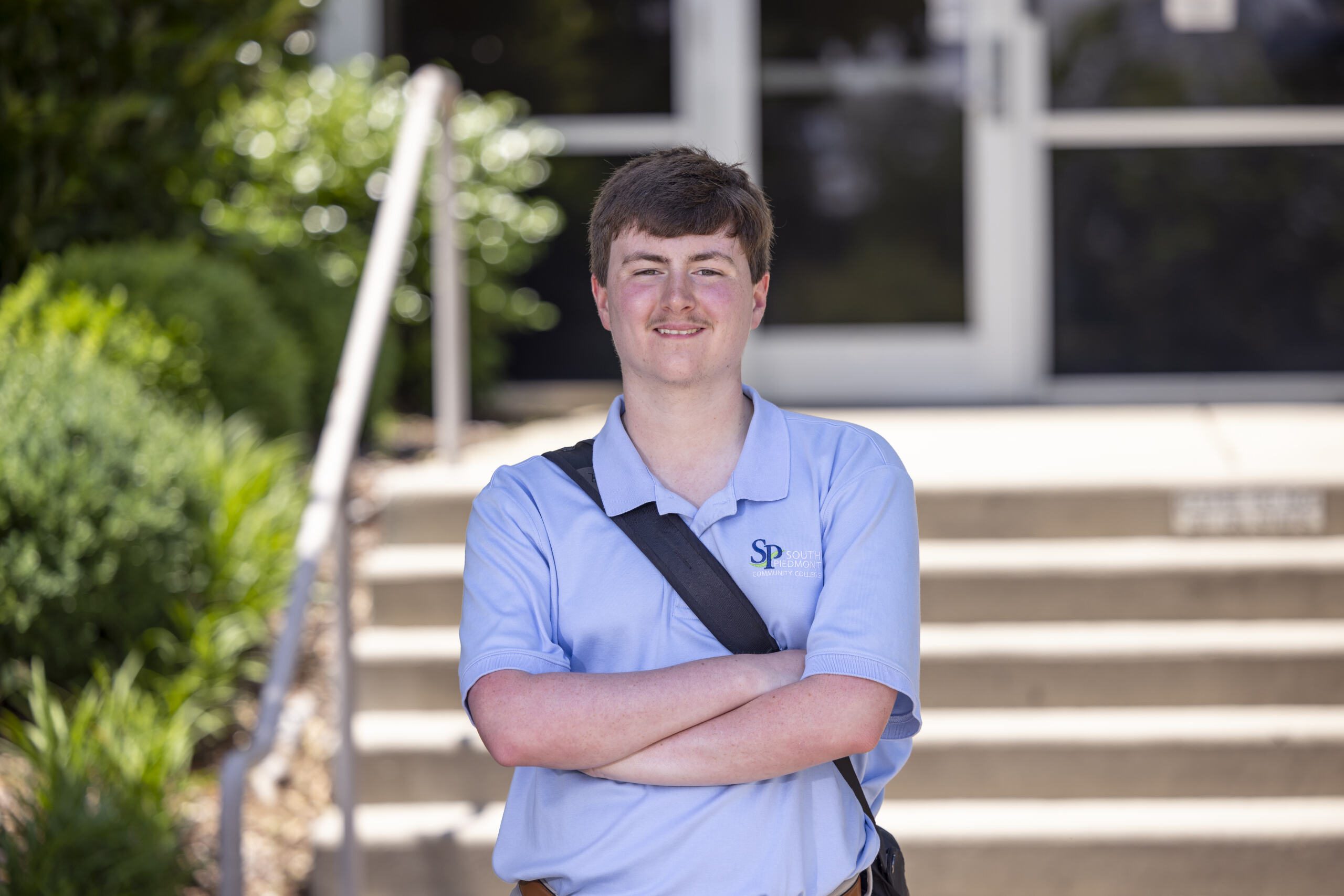 Student standing outside wearing a South Piedmont polo shirt.