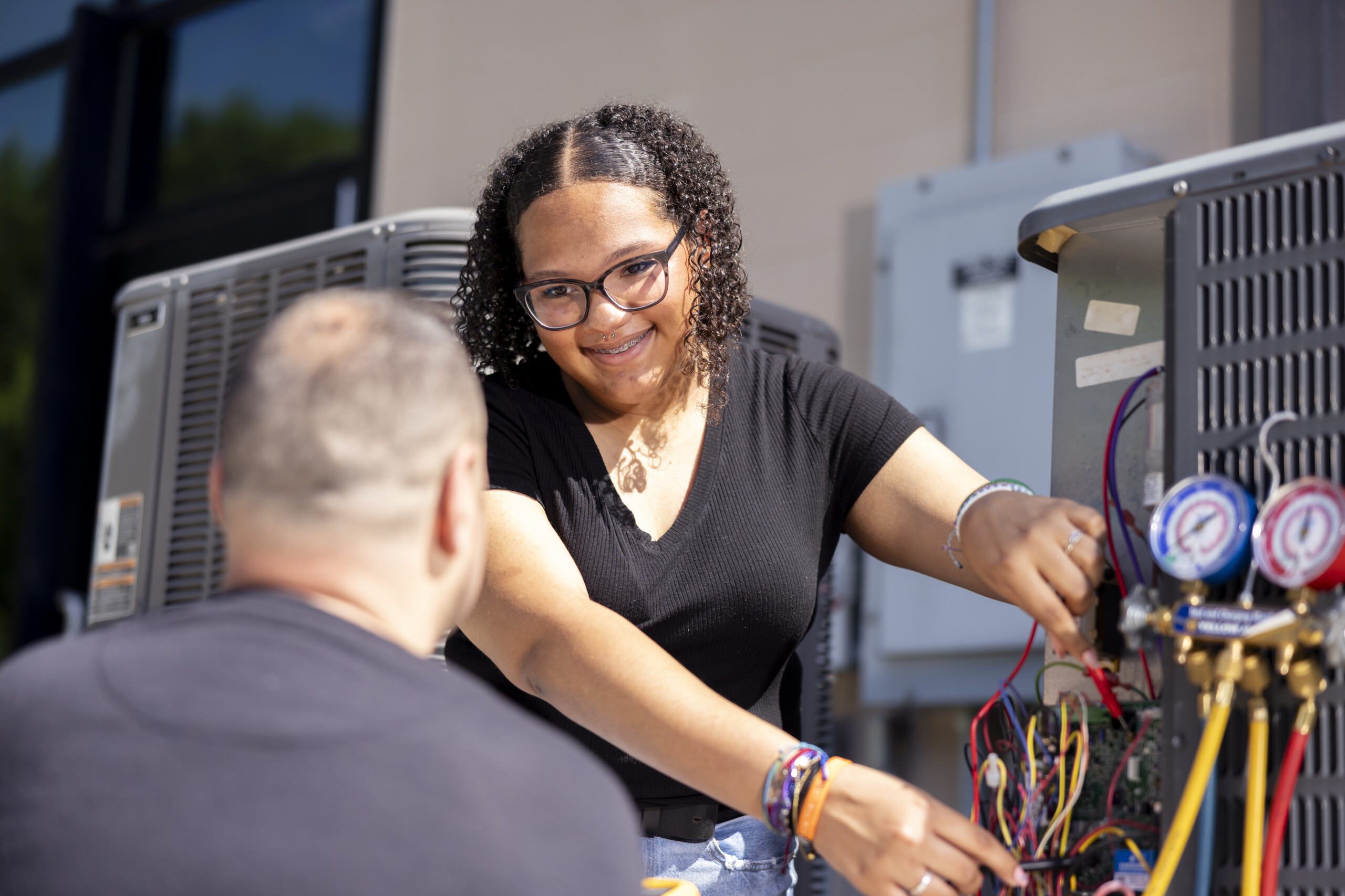 Two HVAC students training outdoors.