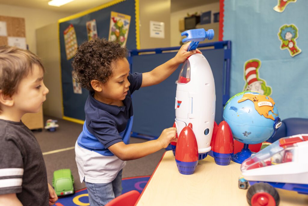 Photo of a young boy playing with a space ship toy at the Smart Start Resource Center.