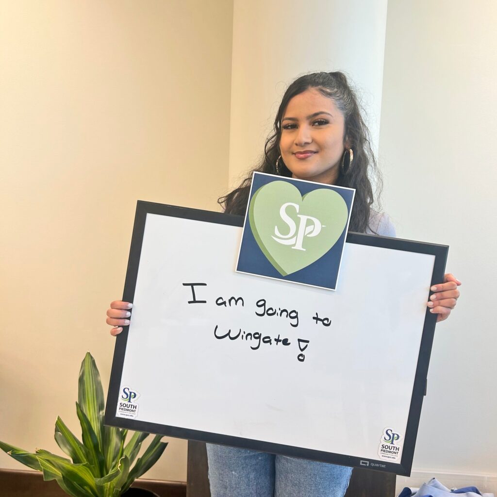 Photo of a girl holding a sign that reads "I am going to Wingate."