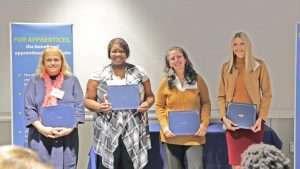 A group of four people holding certificates.