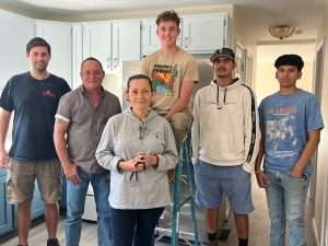 A group of South Piedmont students standing in the kitchen of a renovated home.
