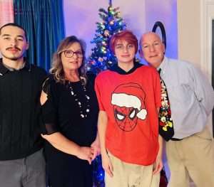 A family standing in front of a Christmas tree.