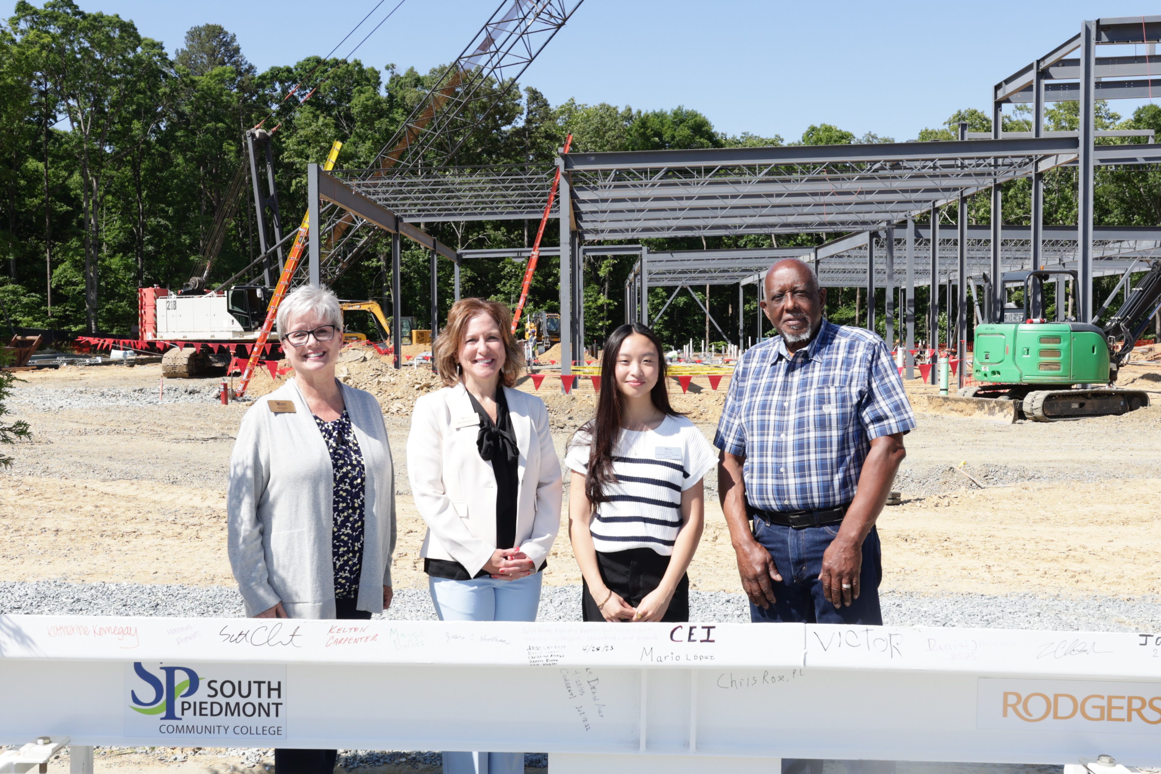 Four people standing in front of a construction site.