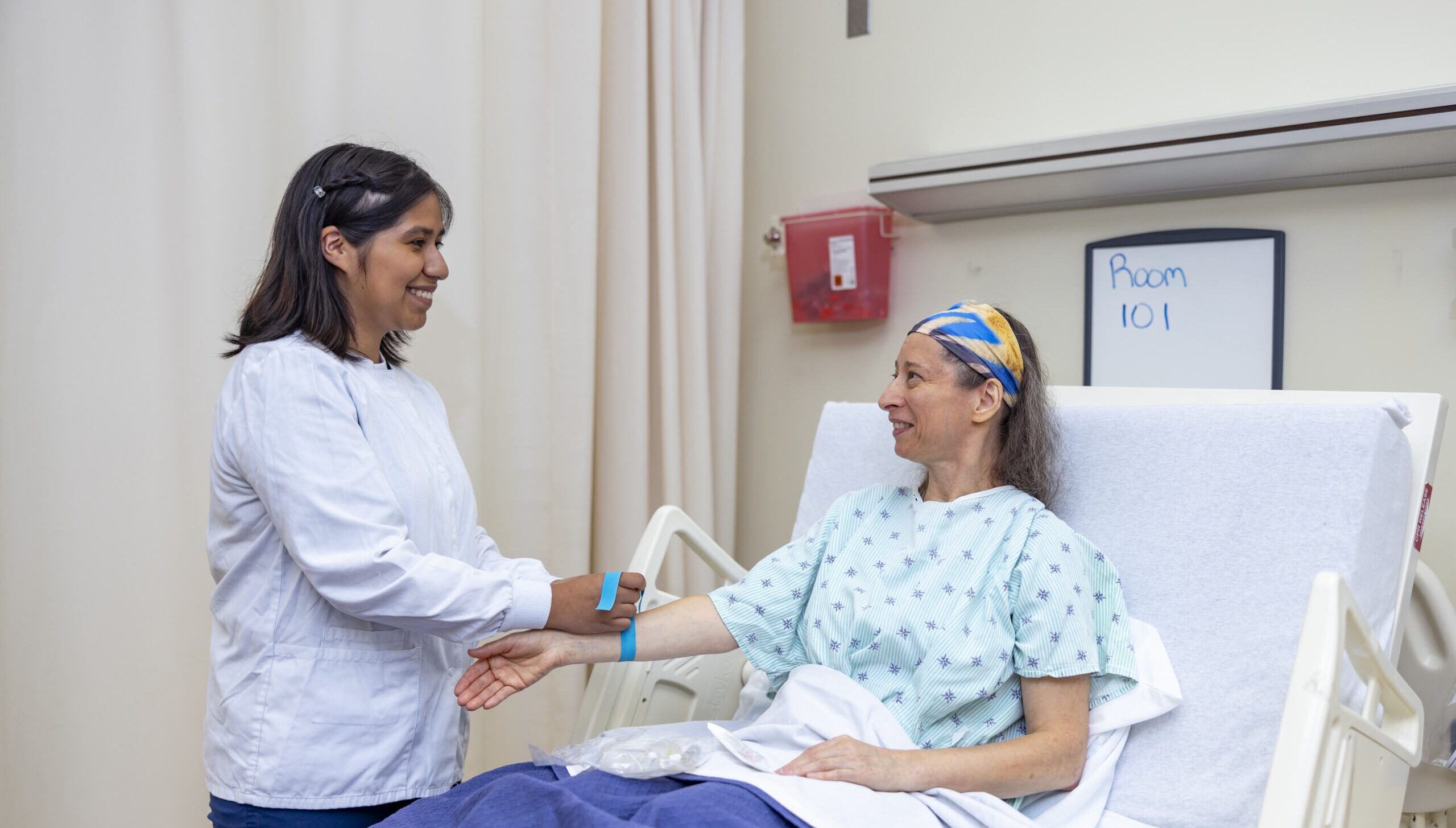 Student nurse preparing a mock patient to draw blood.