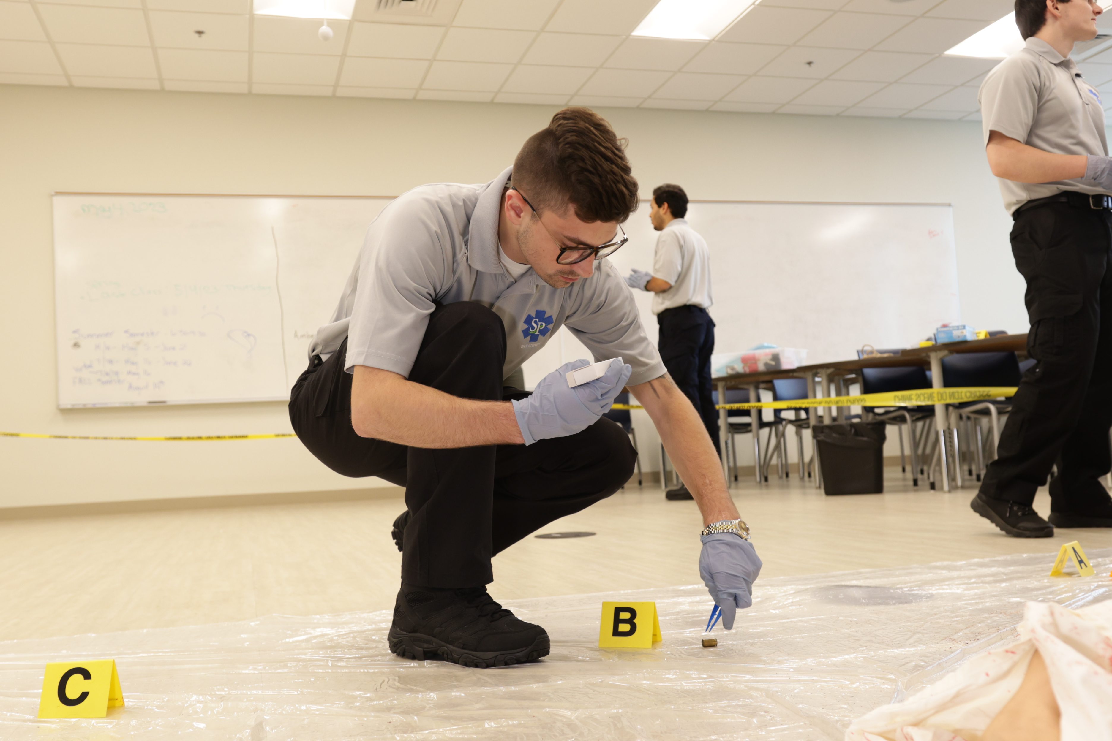 South Piedmont Forensics student collecting evidence in class.