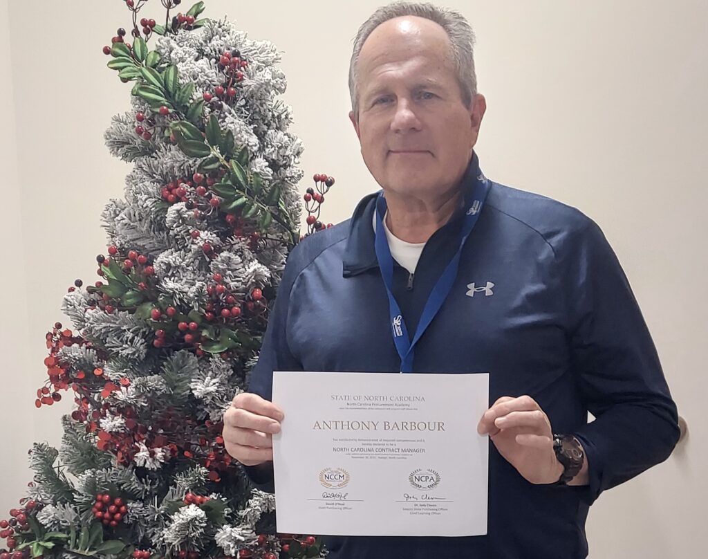 A man holding a certificate.