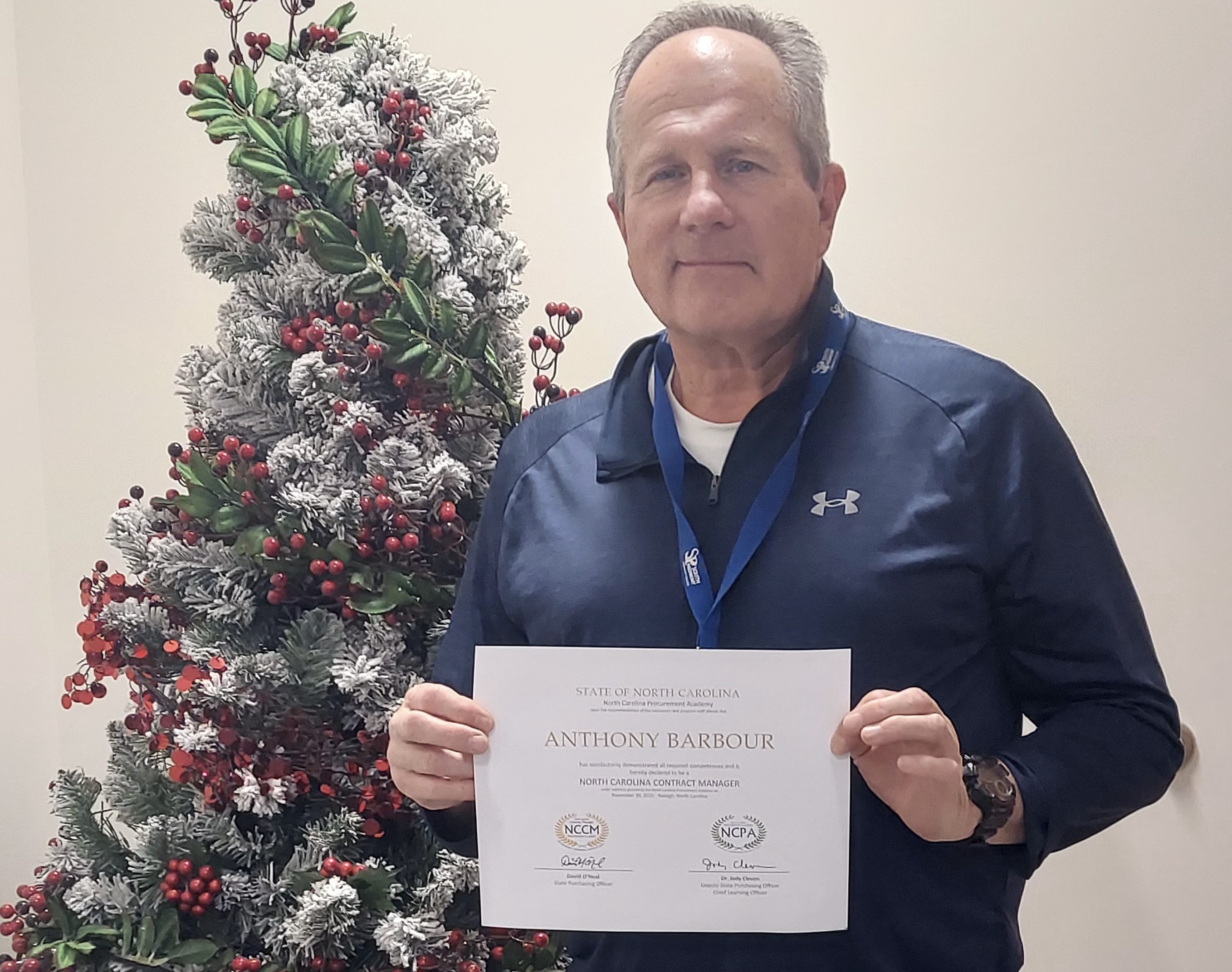 A man holding a certificate.