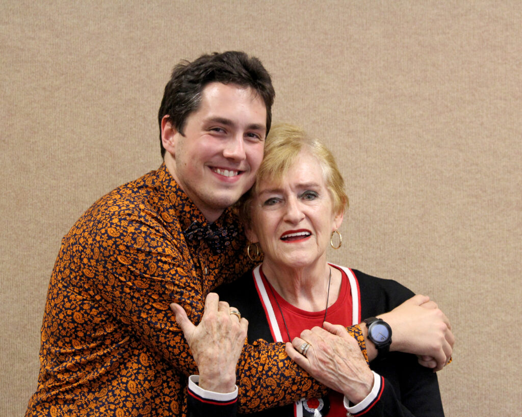 Photo of two people embracing each other and smiling at the camera.