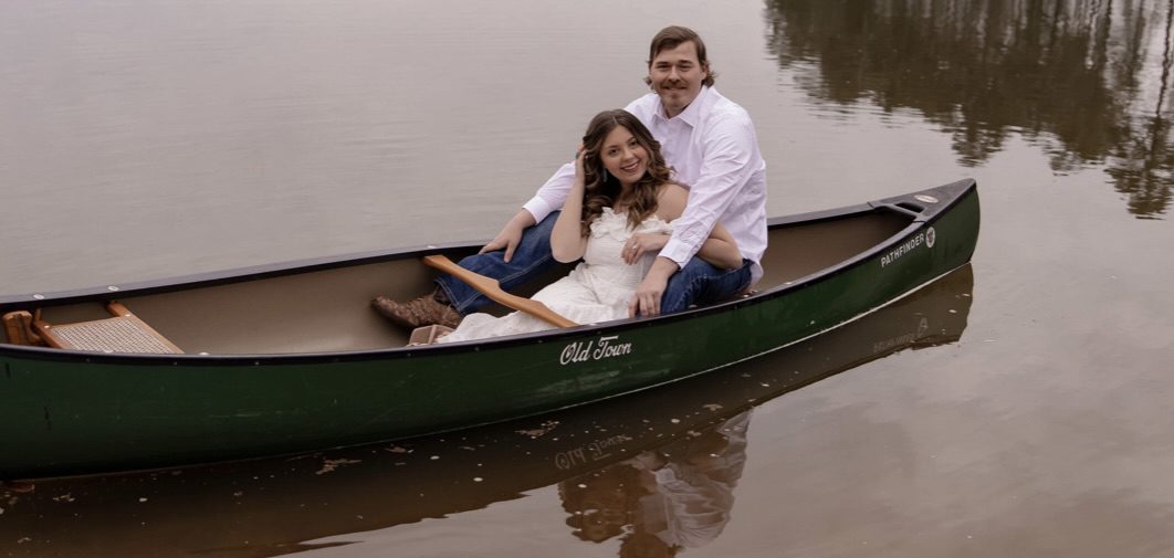 A young couple in a canoe on a cloudy day.