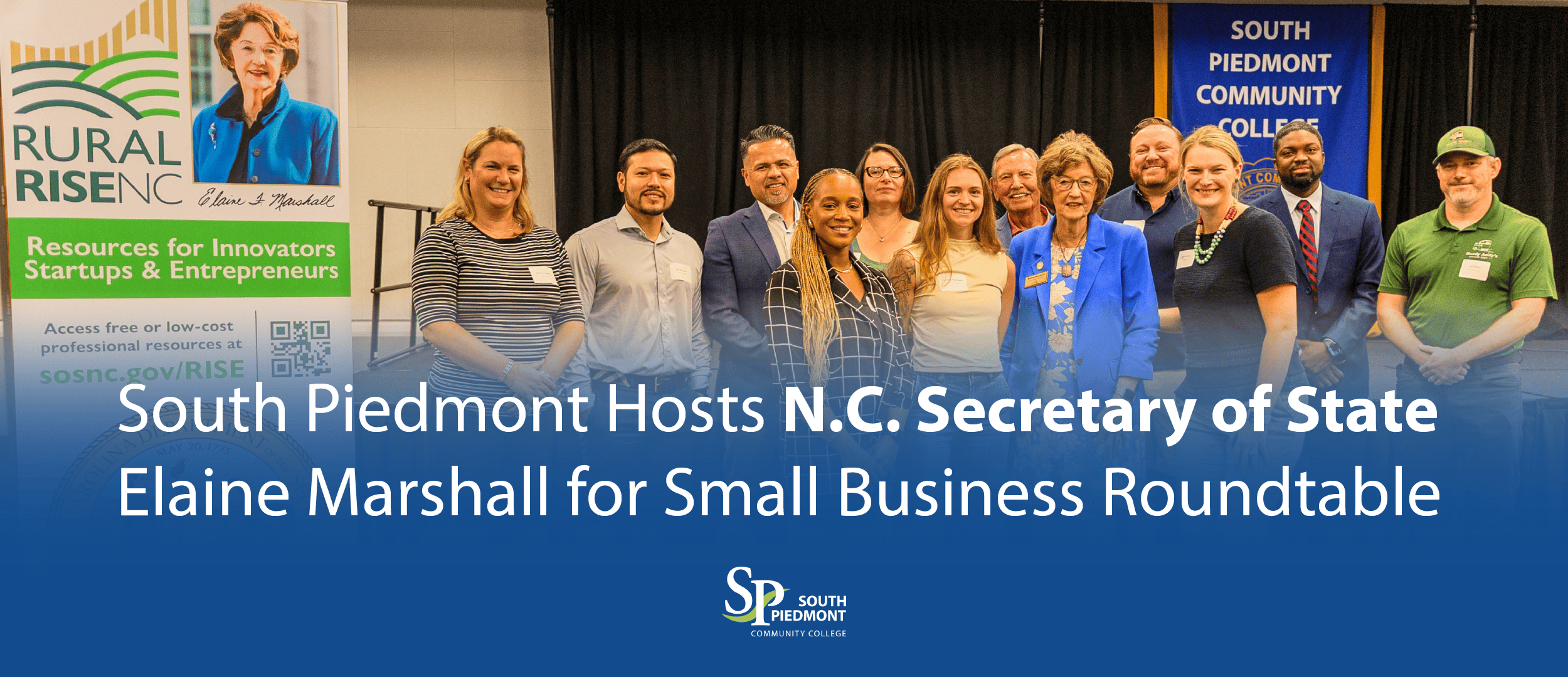 North Carolina Secretary of State Elaine Marshall stands with South Piedmont Community College representatives, local entrepreneurs, and community partners following a small business roundtable at the Old Charlotte Highway Campus. A Rural RISE NC banner featuring Secretary Marshall is displayed on the left, and a South Piedmont Community College banner is visible in the background. Overlaid text reads: "South Piedmont Hosts N.C. Secretary of State Elaine Marshall for Small Business Roundtable."